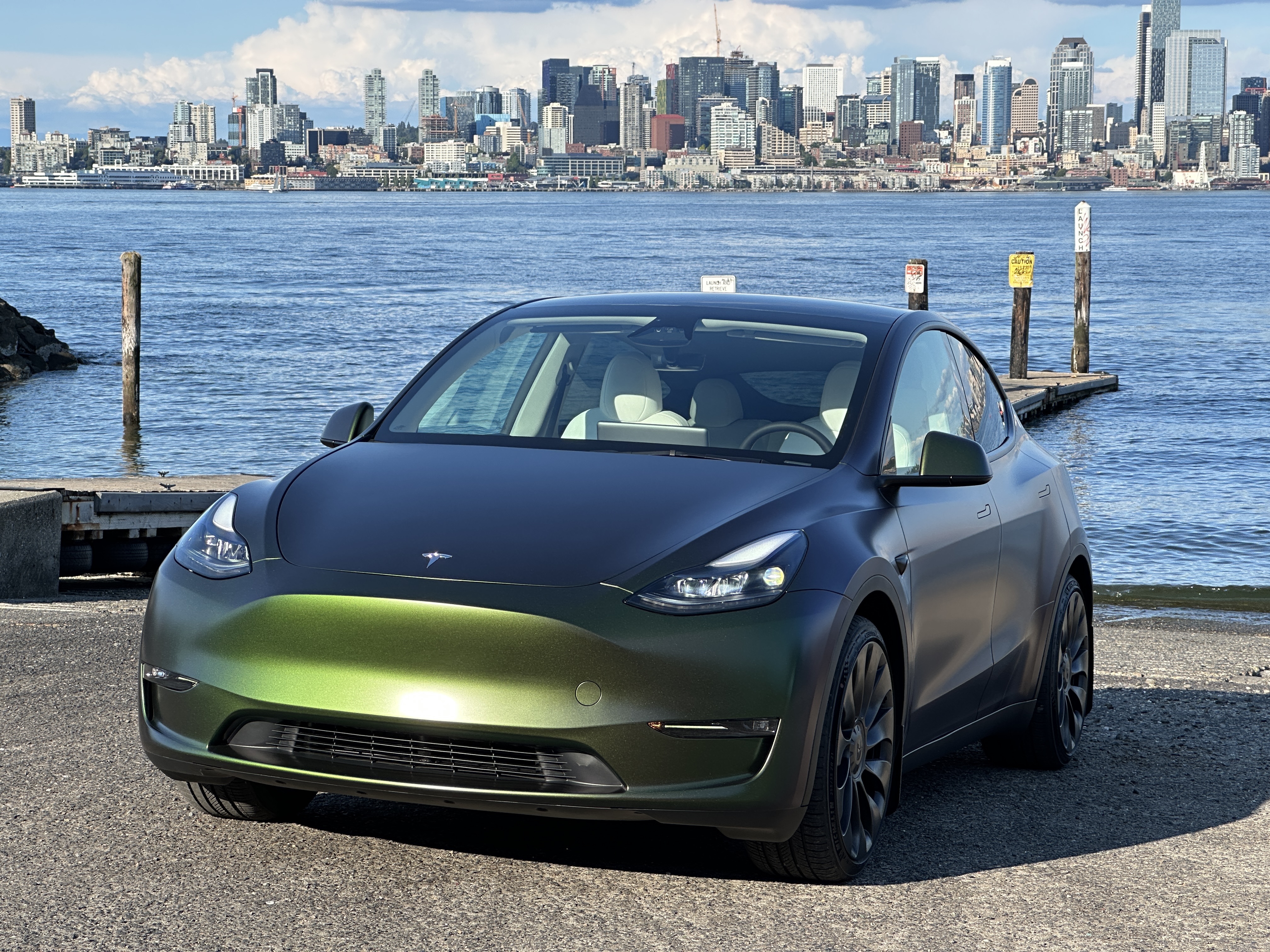 Tesla Model Y olive green wrap with Seattle skyline from front