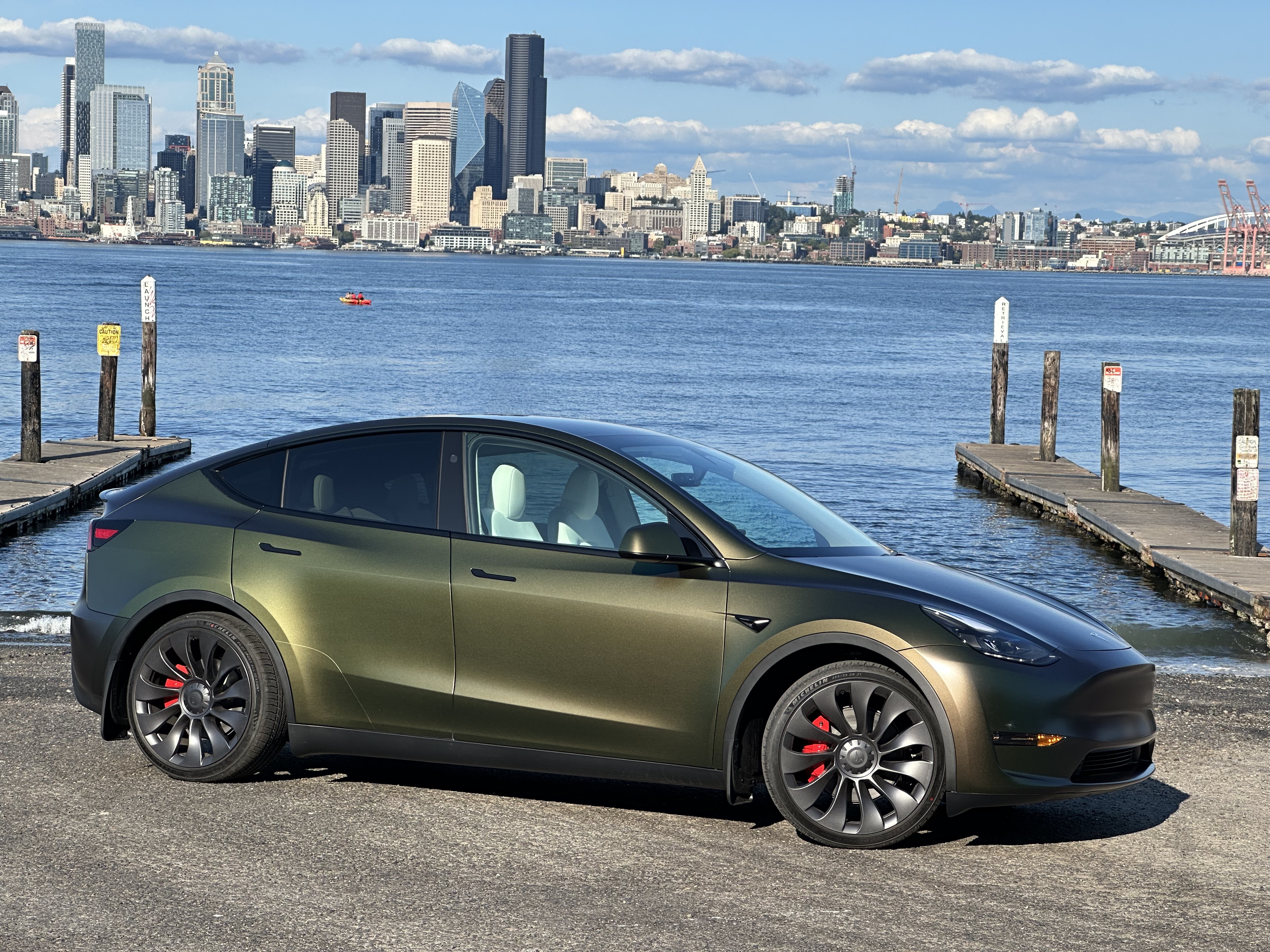 Tesla Model Y in olive green Avery wrap with Seattle skyline