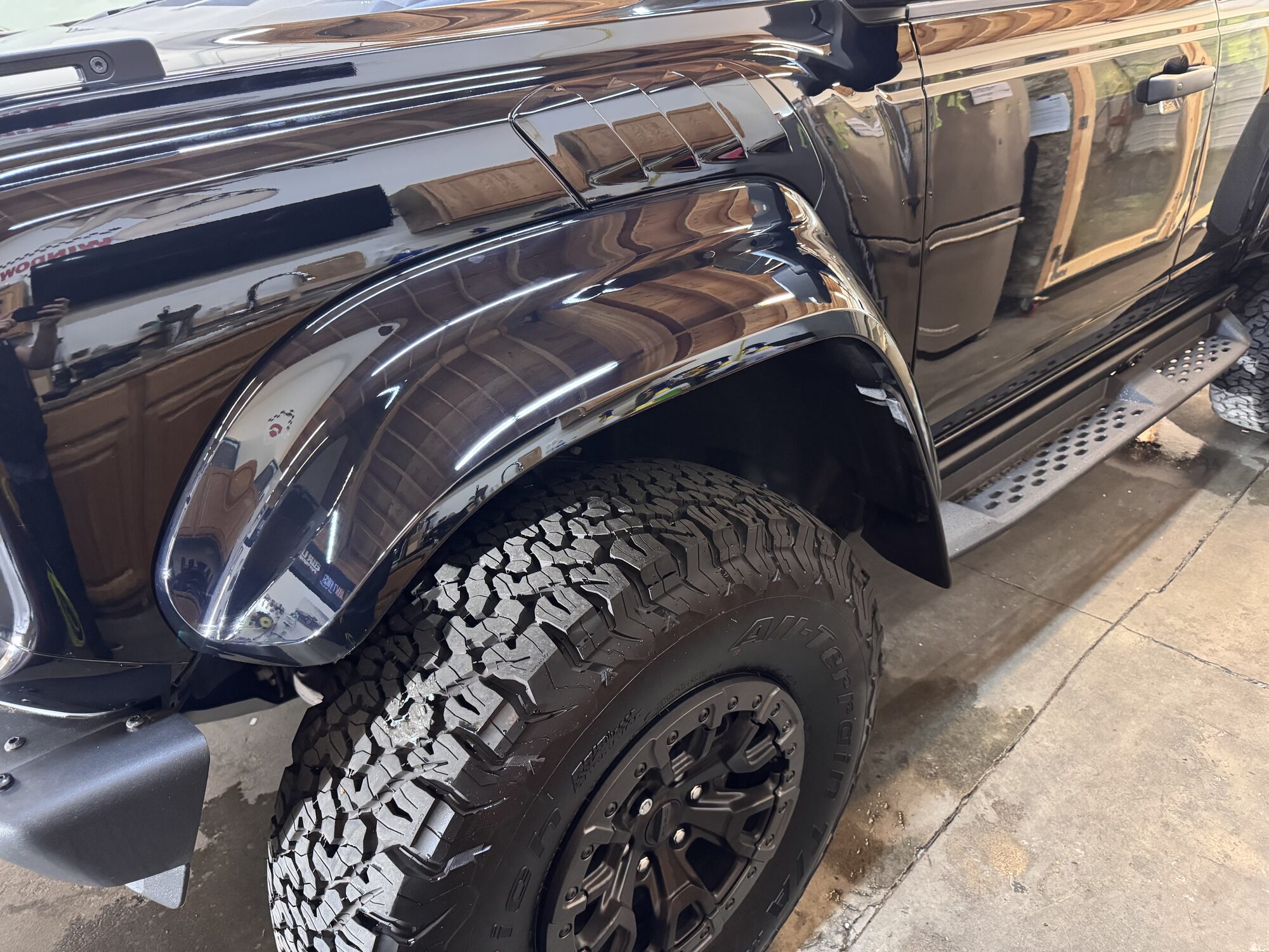 Front fender and wheel arch of a Ford Bronco Raptor under gloss paint protection film at the SeaWraps shop