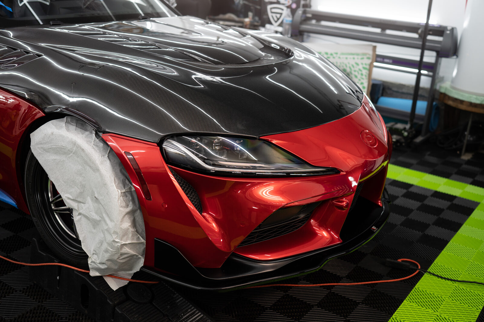 Toyota Supra with a carbon fiber hood wrap being installed at the SeaWraps shop in Kent