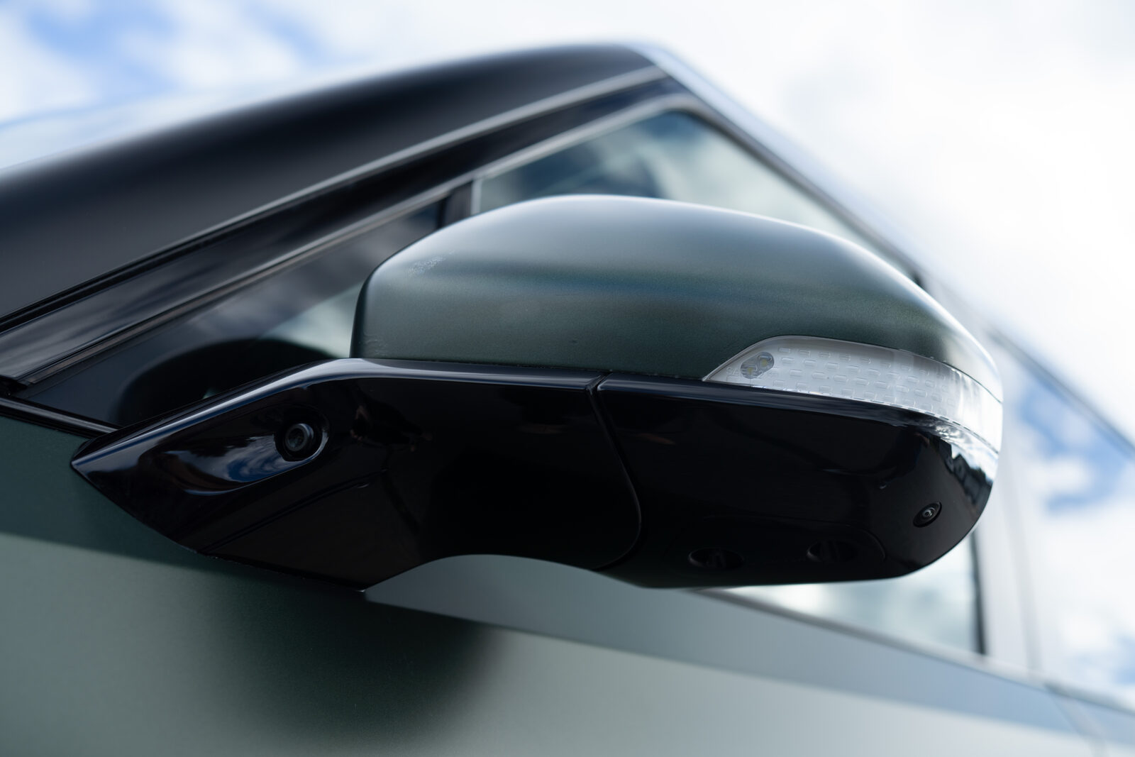 Side mirror and door glass detail on a green Rivian R1S at SeaWraps