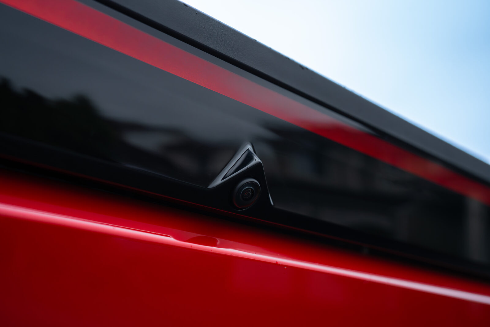 Dark cab side glass and a body-mounted camera pod on a red Tesla Cybertruck at SeaWraps
